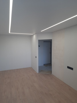 Натяжні стелі зі світловими лініями - модний дизайнерський прийом.